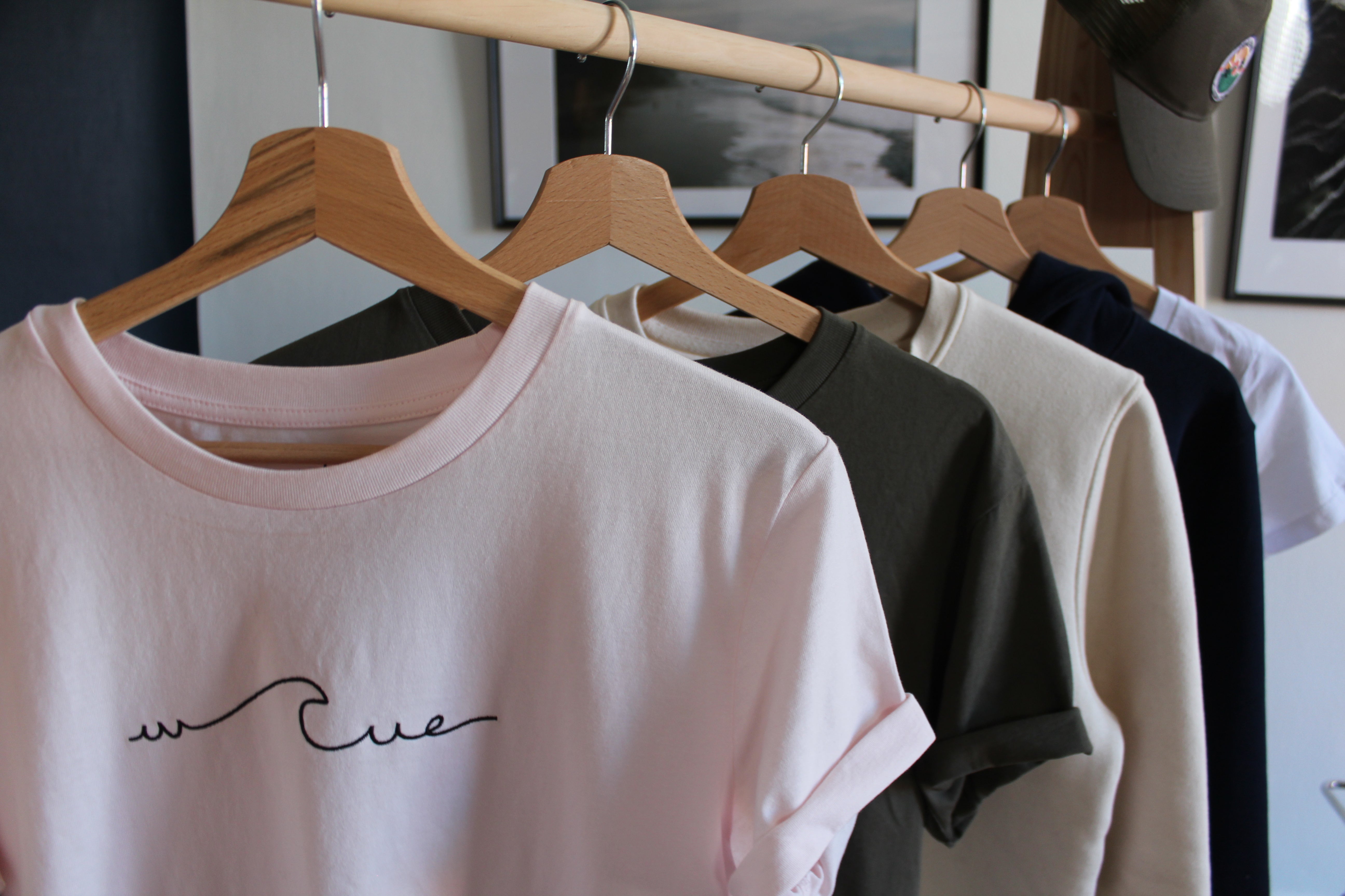 Vêtements sur un portant en bois remplis de t shirts et de sweats de la marque wailoa
